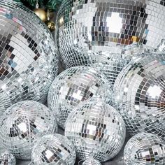 many shiny disco balls sitting next to a christmas tree