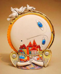 an artisticly designed clock with two birds on it's face and houses in the background