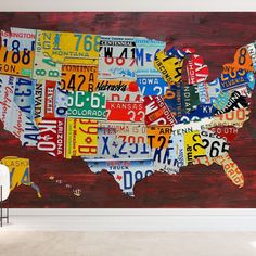 a map of the united states made out of license plates on a wooden wall in an empty room