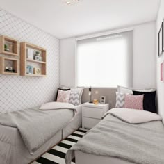 two beds in a small room with white walls and black and white striped rugs