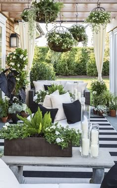 an outdoor living area with potted plants and pillows