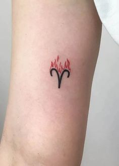 a small tattoo on the leg of a woman's thigh with flames coming out of it