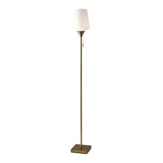 a floor lamp with a white shade on the top and a gold base, standing upright