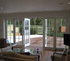 a living room with sliding glass doors leading to an outdoor deck and patio area in the background