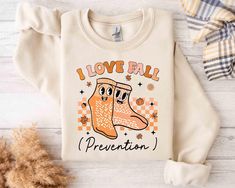 a sweater that says i love ball, and there is a pair of shoes on it