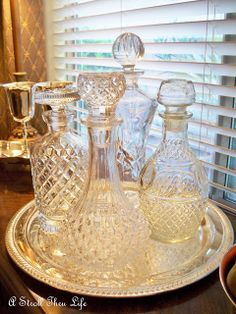 three glass decanters sitting on top of a silver tray