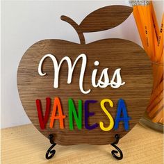 a wooden sign with the word miss vanesa written in multicolored letters on it