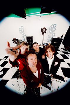 a group of men standing next to each other in front of a white and black checkered floor