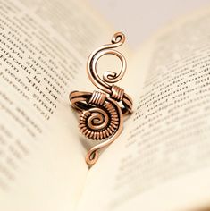 an open book with a metal brooch sitting on top of it