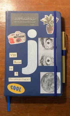 a blue notebook with pictures on it and a pen sitting next to the book's cover