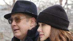 an older man and young woman standing next to each other in the snow wearing hats