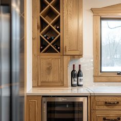 two bottles of wine sitting on top of a kitchen counter next to a microwave oven