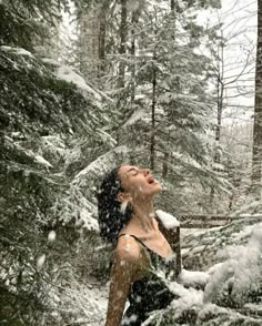 a woman standing in the snow with her eyes closed and mouth wide open looking up