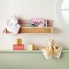 a stuffed unicorn sitting on top of a shelf next to a wooden block and toy