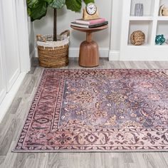 a pink rug in the corner of a room with a potted plant next to it