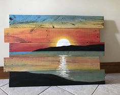 a wooden sign with the sunset painted on it