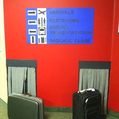 two suitcases sitting in front of a red wall with the words arrivals restrooms ground transportation baggage claim