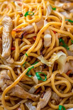 pasta with chicken, onions and parsley in a white bowl