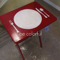 a red table with white plates and silverware on it