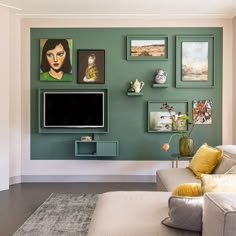 a living room with green walls and pictures on the wall, including a large flat screen tv