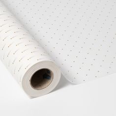 a roll of white paper with gold dots on it