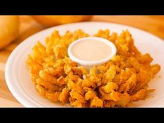 a white plate topped with fried food on top of a wooden table