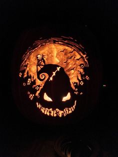 a carved pumpkin with an image of a cat on it's face in the dark