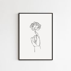 a black and white drawing of a hand holding a flower