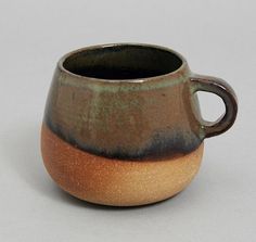 a brown and black cup sitting on top of a table