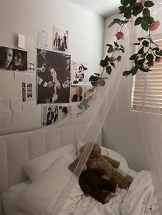 a teddy bear sitting on top of a bed under a white canopy over it's head