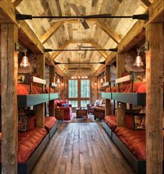 bunk beds are lined up in the middle of a room with wooden walls and ceilings