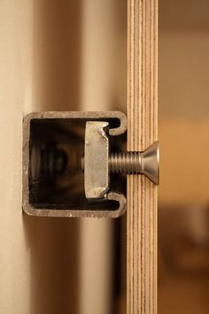 a door handle is attached to the side of a wooden door with a screw in it