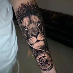 a man's arm with a lion and clock tattoo on the left side of his arm