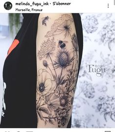 a woman's arm with flowers and bees on it