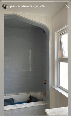 a bath tub sitting next to a window in a bathroom