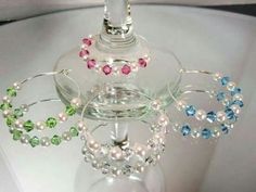 a wine glass with some beads on it and a candle holder in the shape of a chandelier