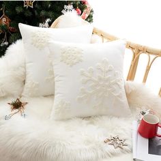 two white pillows sitting on top of a bed next to a christmas tree with decorations