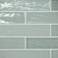 a white brick wall with some water on it's side and the light green paint