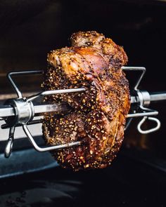 the meat is being cooked on the grill with tongs in it's holder