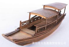 a wooden model of a small boat on white background with chinese writing in the upper corner