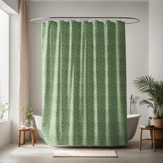 a bathroom with a green shower curtain next to a bathtub and potted plant