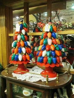 two christmas trees made out of balloons sit on a table