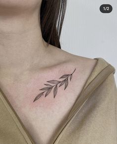 a woman's chest with a small leaf tattoo on the left side of her neck