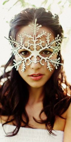 a woman wearing a mask with snowflakes on it's face and eyes