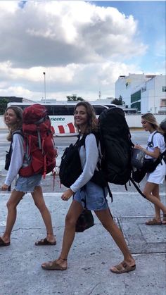 two women walking down the street with backpacks on