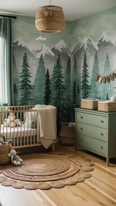 a baby's room with mountains and trees painted on the wall, including a crib