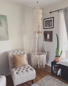 a living room with a white chair and hanging planter