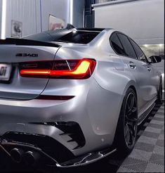 the rear end of a silver car parked in a garage