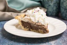 a slice of chocolate pie with whipped cream and sprinkles on a plate