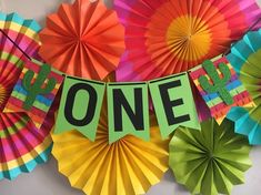 colorful paper fans and decorations with the word up on one sign hanging from it's side